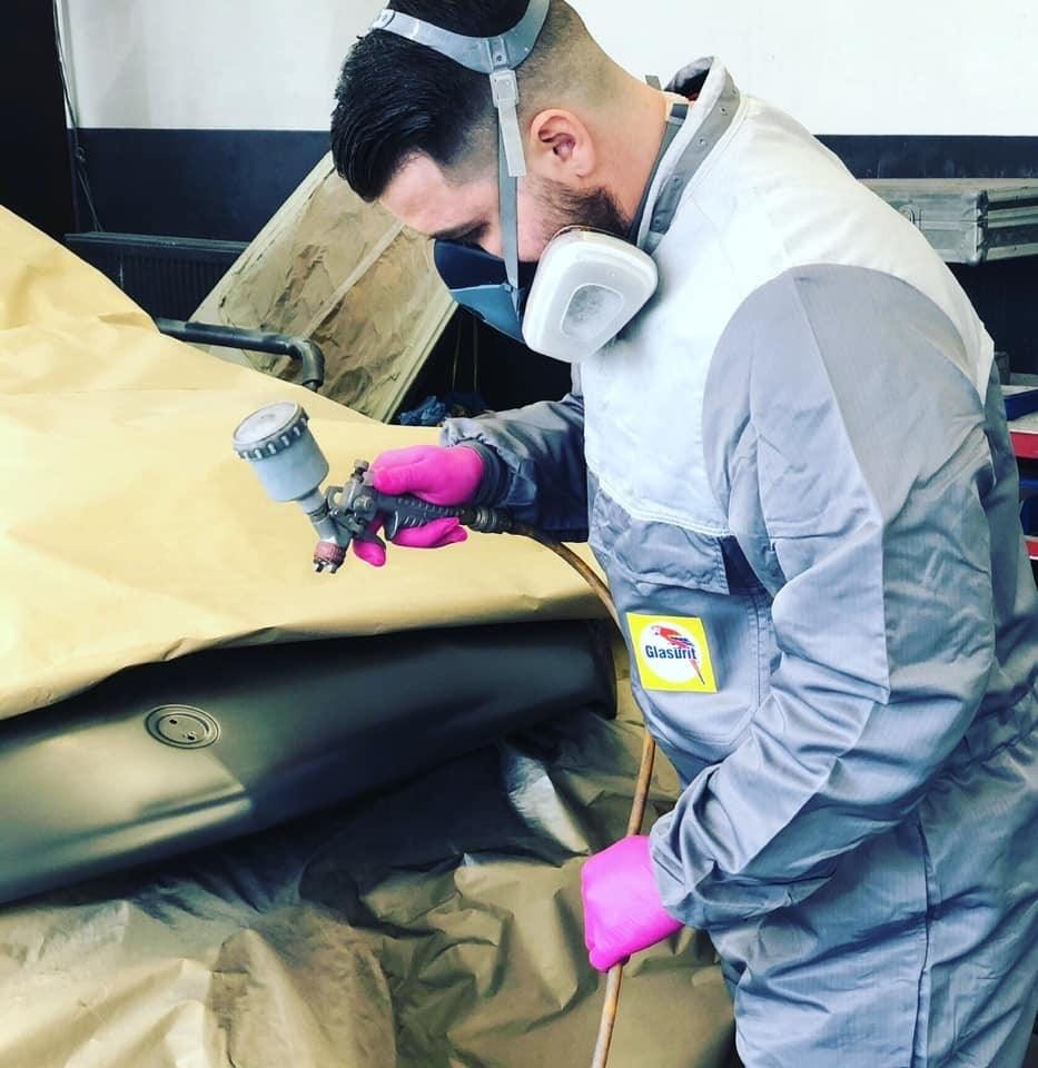 Lackierer mit Lackierpistole bei der Arbeit